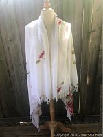 Front view of white sarong scarf with red hibiscus floral print on mannequin outdoors, showing size and drape.