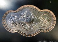 Top-down view of the pink cut glass serving tray showing detailed starburst and geometric patterns.