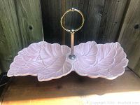 Full view of the dual leaf ceramic tray with metal center handle, showing shape, color and handle details.