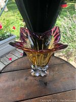 Front angled view showcasing the amber to purple glass gradient and the ornate bubble feet base.