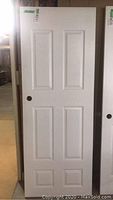 Full view of the white 80x30 wooden interior door showing six panel design and pre-drilled handle hole.