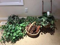 Artificial greenery plants and basket of pinecones arranged on floor
