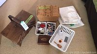 Overview of two wooden sewing boxes, wicker basket, and baskets with sewing supplies including buttons and thread