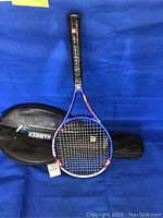 Wilson Hyper Hammer tennis racket resting on blue background showing racket head and handle details.