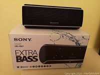 Sony SRS-XB21 Bluetooth speaker placed on top of the original product box which shows the model and branding details.