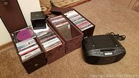 Full lot view showing Sony portable player and three leather-look CD cases with many CDs inside