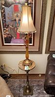 Photo of tri-light table lamp with beaded fabric shade placed on the pedestal table with marble-look top, showing overall height and style
