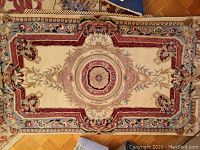 Full top view of the rectangular Capel wool area rug showing entire gold-colored central medallion and surrounding pattern.