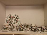 Shelf view showing platter, saucers, mugs, cups and small bowls
