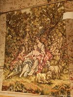 Full view of the tapestry showing the pastoral scene and hanging rod with finials.