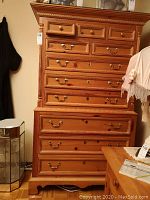 Full front view of pine tallboy dresser showing all drawers and top decorative molding