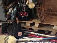 Photo showing various garden tools including leaf rake, broom, shovels, and Husky tool bag with pruning tools.