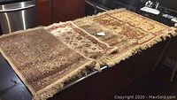 Five small vintage Persian prayer rugs arranged side by side, showing various patterns and fringed edges