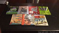 Photo of seven children's fact and educational books including multiple Guinness World Records editions and science and facts books.
