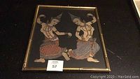 Original metallic painting of two dancers in traditional attire framed behind glass with gold tone wood featuring bamboo style edges on black background.