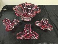 Full set of cranberry glass bowls on black cloth, showing one large bowl and three smaller ones