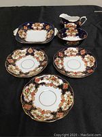 Full set showing cream pitcher, sugar bowl, candy dish, and three saucers with cobalt blue and floral pattern