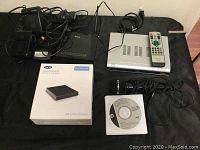 Photo showing all items: Tivax TV converter with remote, Lacie DVD drive box, D-Link modem, microphone, headphones, Sony speakers, driver recovery DVDs.