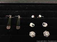 Overview of 4 pairs of 925 silver earrings in black display case