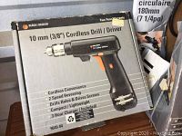 Box showing Black and Decker 10mm (3/8") cordless drill/driver with product details and warranty information