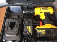 DeWalt 18V cordless drill, charger, and battery inside open black carry case with compartments.