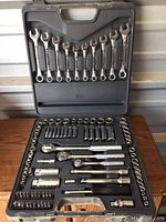 Socket and wrench set open in plastic case showing all wrenches and socket tools