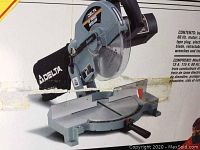 Photo showing the Delta 10-inch power mitre saw with blade guard, adjustable base, and handle.
