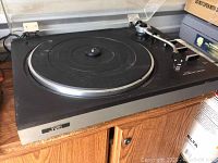 Full view of the JVC turntable showing the platter, tonearm, and base with visible dust and scratches.