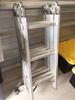 Folded ladder in upright position against wall