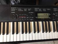 Close-up photo of the left side of the keyboard showing keys and Casio CTK-3200 model branding with the LCD display and function buttons visible.