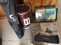 Photo showing assembled lot with two rolled gear items in front and two boxed air mattresses beside each other.