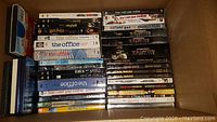 Photo showing DVD collection with titles including The Office, How I Met Your Mother, Harry Potter, Star Wars, and others, arranged in piles.