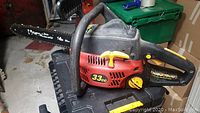 Side view of Homelite Ranger chainsaw showing 33cc decal and yellow controls on red engine casing with black handle and 14 inch bar.