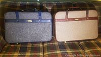 Two Samsonite luggage pieces displayed side by side on a plaid sofa, showing front surfaces and handles