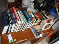 Wide view of all books lined up on a wooden surface with one wood book end