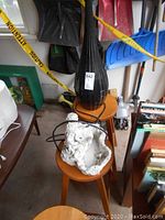 Photo of black plastic humidifier diffuser and white resin garden fountain with foot damage placed on small wooden stools