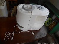 Side view showing humidifier with attached power cord on wooden table.
