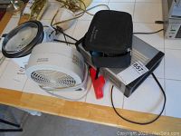 Lot on table showing small fan, historic heater, rice cooker, and black case for spa system