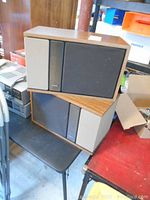 Stack of two Bose 301 Series II speakers showing front cloth grills and woodgrain vinyl veneered cabinets