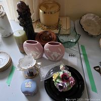 Tabletop view showing multiple items including candles, vases, Wedgwood jasperware box, figurines and glassware