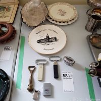 Wide view of all items including plates, silver tray, lighters, and bottle openers
