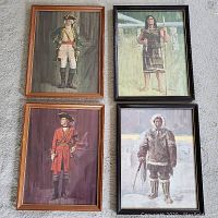 Four framed historical prints including two soldiers and two indigenous people prints, laid on carpet.