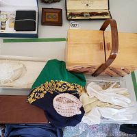 Lot items atop a flat surface showing Hermes style silk scarf, white cotton gloves, pink baby bonnet, small wooden sewing box, and a wooden box with brooch inside.