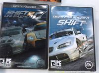Photo of both game cases: Need for Speed Shift and Need for Speed Shift 2 Unleashed Limited Edition side by side with visible cover art and ratings.