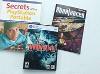 Image of three items: Secrets of PlayStation Portable guide book, Wolfenstein PC game case, and Star Lancer booklet.