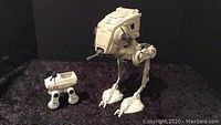Photo of Kenner Star Wars AT-ST and MTV-7 Mini-Rig toys on dark surface.