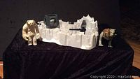 Wide view of the white Hoth Imperial Attack Base playset with Wampa and Tauntaun figures on a black cloth.