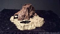 Front-left angle of the Dagobah set, showing the rocky plastic base and large brown tree stump with holes.