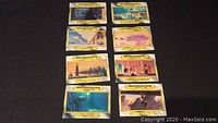 Eight yellow bordered Star Wars trading cards laid out in two columns on a black surface. Various space paintings by Ralph McQuarrie from The Empire Strikes Back movie depicted on cards.