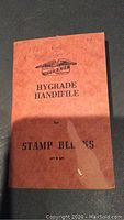 Cover of the orange Hygrade Handfile book for stamp blocks marked 1961-1962 with some wear and a small tear.